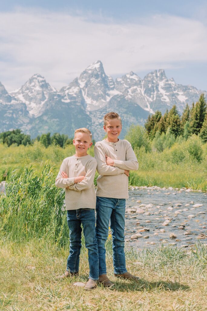 rust dress family photos with mountain backdrop boys posing naturally during Grand Teton photography session family playing in water during professional photo session Grand Teton sunrise family portraits at Schwabacher Landing cream and rust color palette mountain family photos