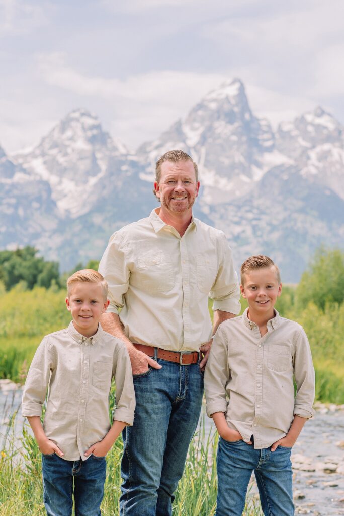 rust dress family photos with mountain backdrop boys posing naturally during Grand Teton photography session family playing in water during professional photo session Grand Teton sunrise family portraits at Schwabacher Landing cream and rust color palette mountain family photos