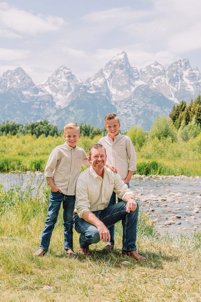 rust dress family photos with mountain backdrop boys posing naturally during Grand Teton photography session family playing in water during professional photo session Grand Teton sunrise family portraits at Schwabacher Landing cream and rust color palette mountain family photos