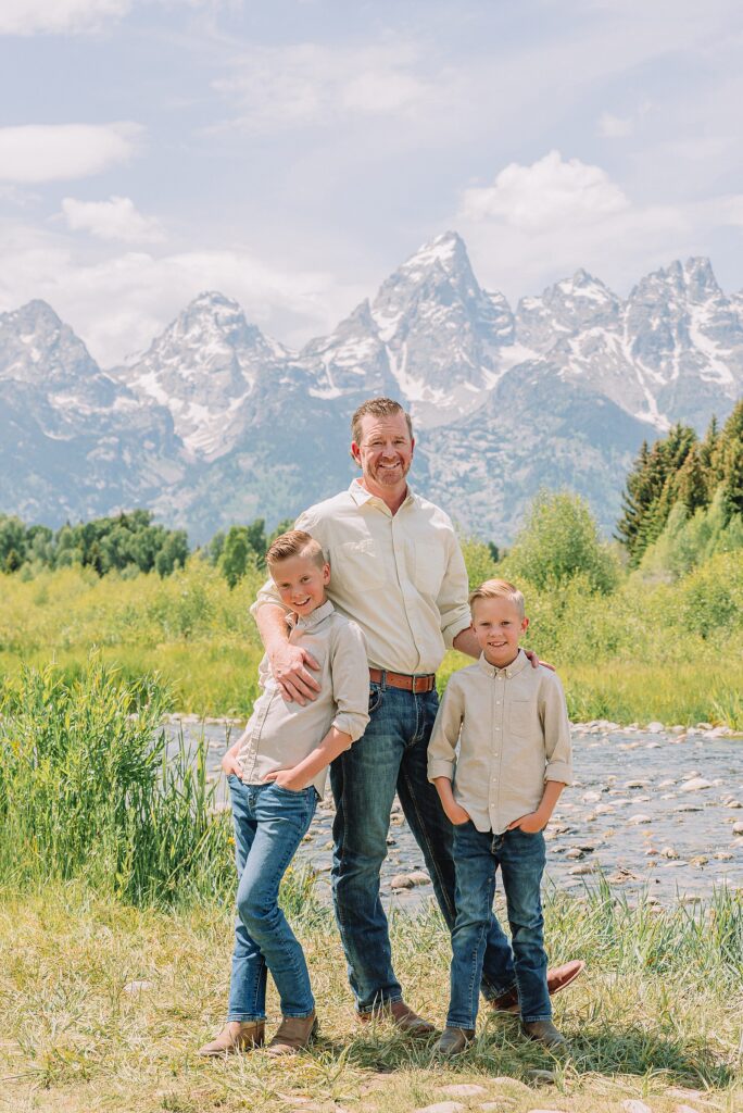 rust dress family photos with mountain backdrop boys posing naturally during Grand Teton photography session family playing in water during professional photo session Grand Teton sunrise family portraits at Schwabacher Landing cream and rust color palette mountain family photos