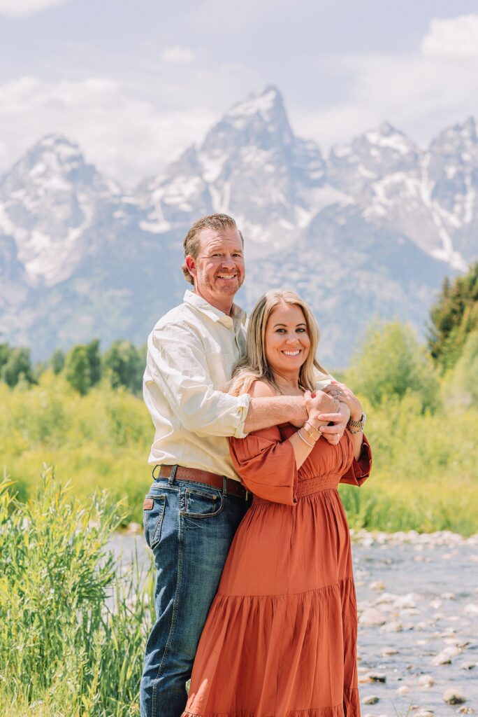 summer family photography session in Jackson Hole Wyoming coordinated outfit ideas for family photos in the mountains rust dress family photos with mountain backdrop boys posing naturally during Grand Teton photography session