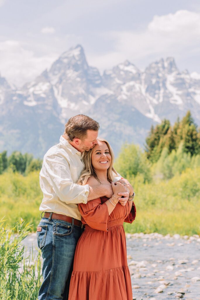 summer family photography session in Jackson Hole Wyoming coordinated outfit ideas for family photos in the mountains rust dress family photos with mountain backdrop boys posing naturally during Grand Teton photography session
