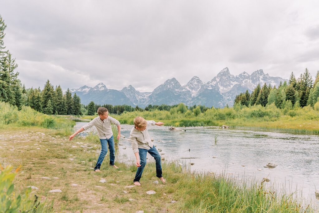 family playing in water during professional photo session Grand Teton sunrise family portraits at Schwabacher Landing cream and rust color palette mountain family photos Grand Teton vacation photographer coordinating family outfits without matching