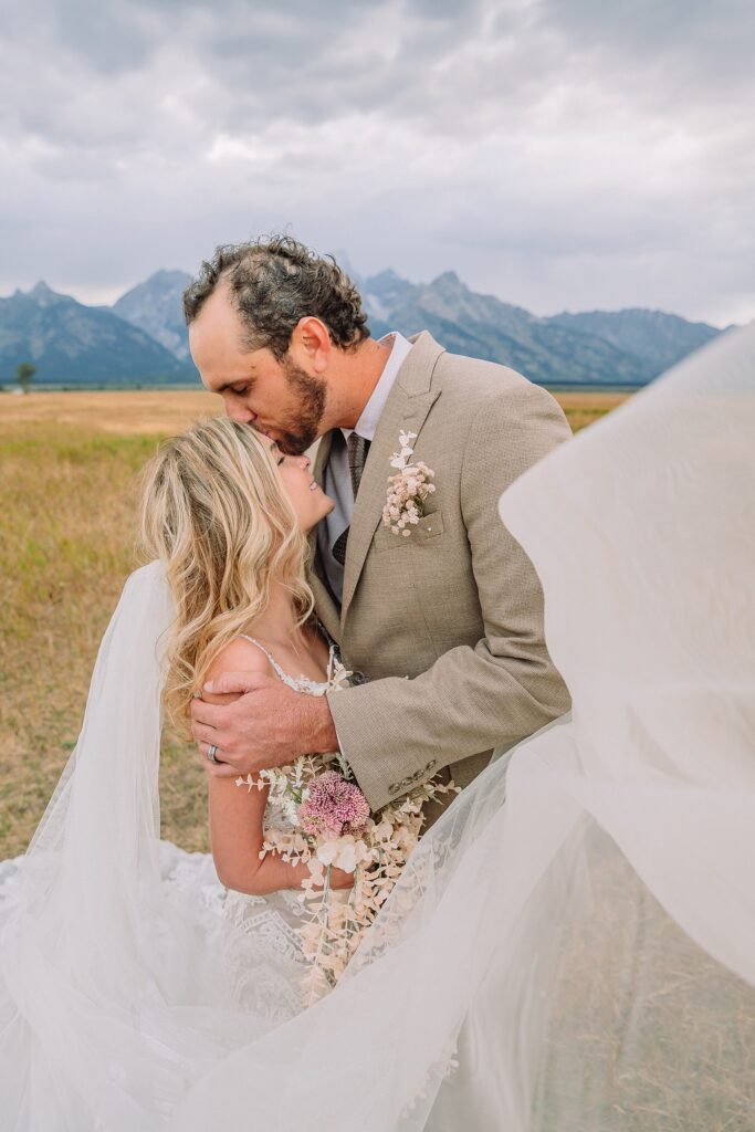 Mormon Row Grand Teton wedding ceremony cathedral veil alpine wedding photography fall colors Grand Teton elopement intimate outdoor micro wedding Wyoming champagne toast Grand Teton wedding celebration semi-formal outdoor alpine wedding attire first look Mormon Row Grand Tetons