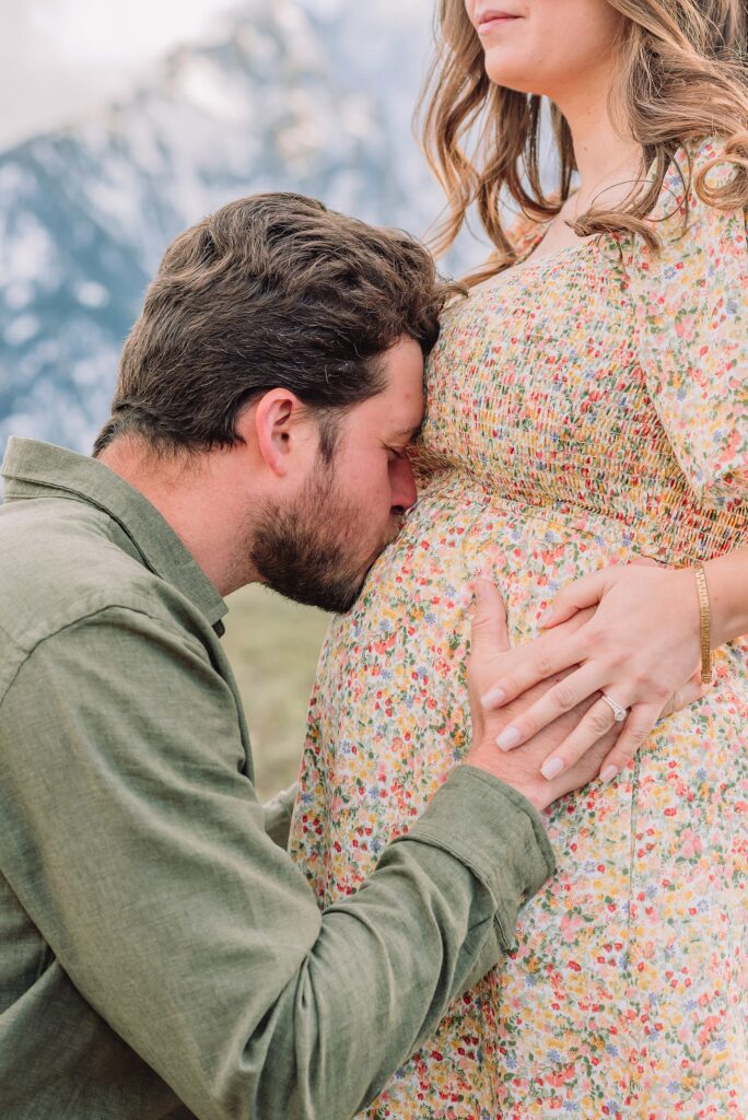 Jackson Hole babymoon maternity photos at Cathedral View Turnout Grand Teton National Park maternity session in spring Cathedral View Turnout couple photos snow capped peaks Flowery maternity dress mountain photography Jackson Hole Jackson Hole Maternity Photographer