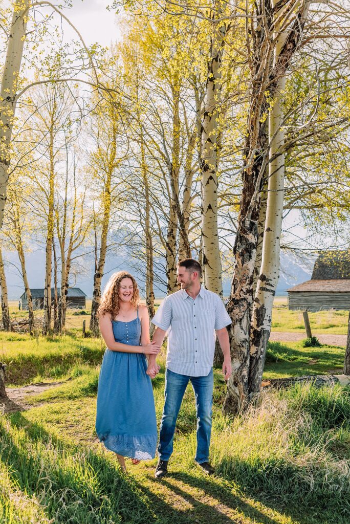 golden hour couples photography Mormon Row Jackson Hole Teton mountain backdrop engagement photos Wyoming blue coordinated outfits couples portraits Grand Tetons historic barn couples photography Jackson Hole Wyoming spring aspen trees anniversary session Mormon Row rustic fence line portraits Grand Teton National Park