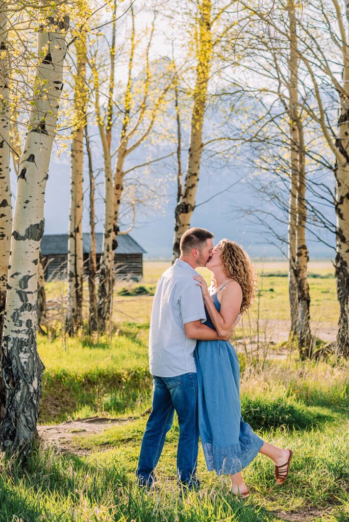 golden hour couples photography Mormon Row Jackson Hole Teton mountain backdrop engagement photos Wyoming blue coordinated outfits couples portraits Grand Tetons historic barn couples photography Jackson Hole Wyoming spring aspen trees anniversary session Mormon Row rustic fence line portraits Grand Teton National Park