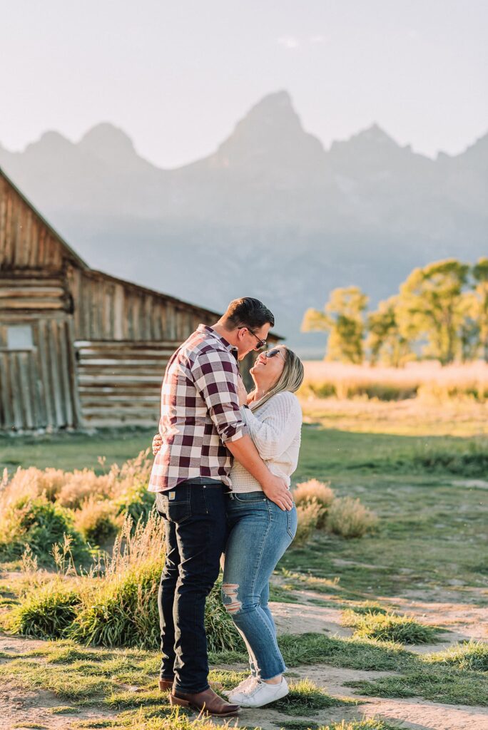 Mormon Row barn proposal photography Jackson Hole Wyoming Sunset engagement photos at TA Moulton Barn Surprise proposal photographer Grand Teton National Park Golden hour mountain proposal photography Jackson Hole Authentic couple portraits Mormon Row historic barn