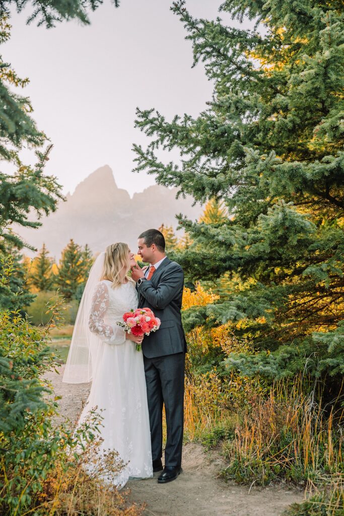 fall bridal portraits at Schwabacher Landing Jackson Hole Grand Teton National Park engagement photos String Lake bride in lace wedding dress with mountain backdrop Wyoming Schwabacher Landing fall color wedding photography Jackson Hole couple portraits with Snake River reflection bride and groom in fall foliage Grand Teton Wyoming rust orange tie groom wedding portraits Jackson Hole fall September engagement photos String Lake Teton National Park
