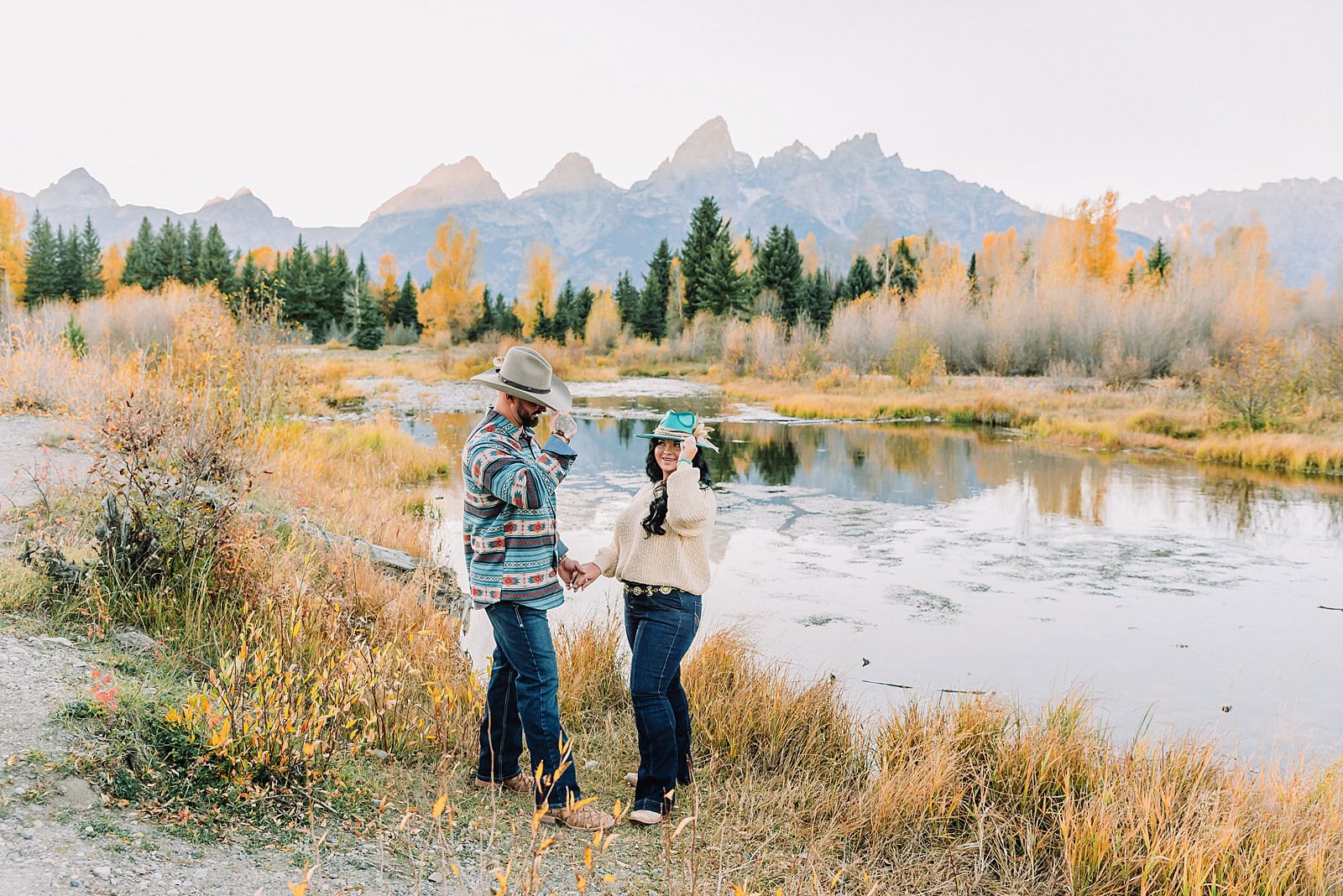 couple wearing custom engraved western hats at Grand Teton elopement turquoise wedding jewelry details at Jackson Hole mountain wedding horseback riding wedding party tour at Spring Creek Ranch Wyoming Schwabacher Landing sunset elopement portraits in Grand Teton National Park casual outfit change for relaxed mountain elopement photos split day wedding coverage for destination elopement couples flexible elopement timeline for Jackson Hole micro wedding western jeans and sweater look for Wyoming vacation style portraits