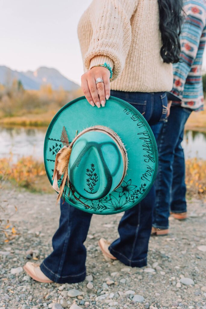 couple wearing custom engraved western hats at Grand Teton elopement turquoise wedding jewelry details at Jackson Hole mountain wedding horseback riding wedding party tour at Spring Creek Ranch Wyoming Schwabacher Landing sunset elopement portraits in Grand Teton National Park casual outfit change for relaxed mountain elopement photos split day wedding coverage for destination elopement couples flexible elopement timeline for Jackson Hole micro wedding western jeans and sweater look for Wyoming vacation style portraits