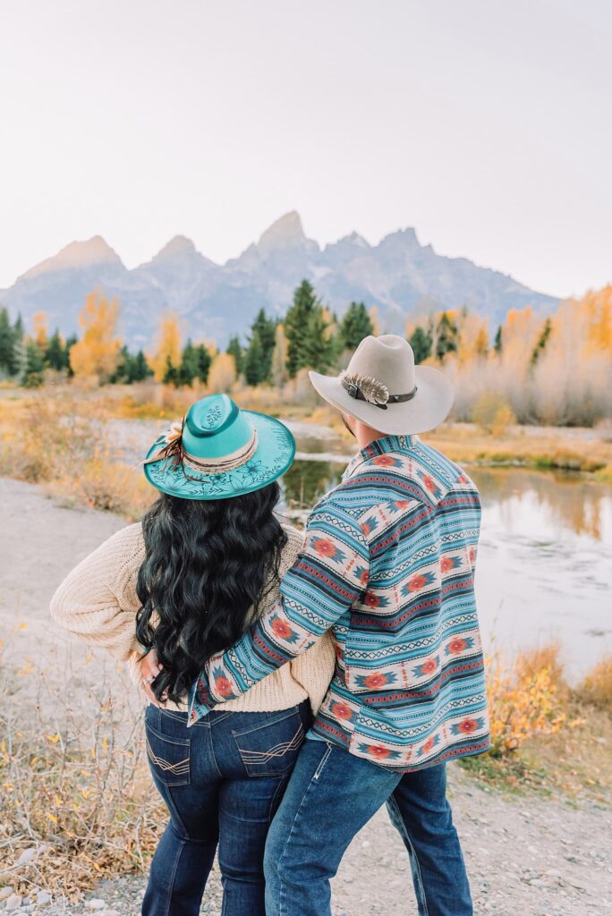 couple wearing custom engraved western hats at Grand Teton elopement turquoise wedding jewelry details at Jackson Hole mountain wedding horseback riding wedding party tour at Spring Creek Ranch Wyoming Schwabacher Landing sunset elopement portraits in Grand Teton National Park casual outfit change for relaxed mountain elopement photos split day wedding coverage for destination elopement couples flexible elopement timeline for Jackson Hole micro wedding western jeans and sweater look for Wyoming vacation style portraits