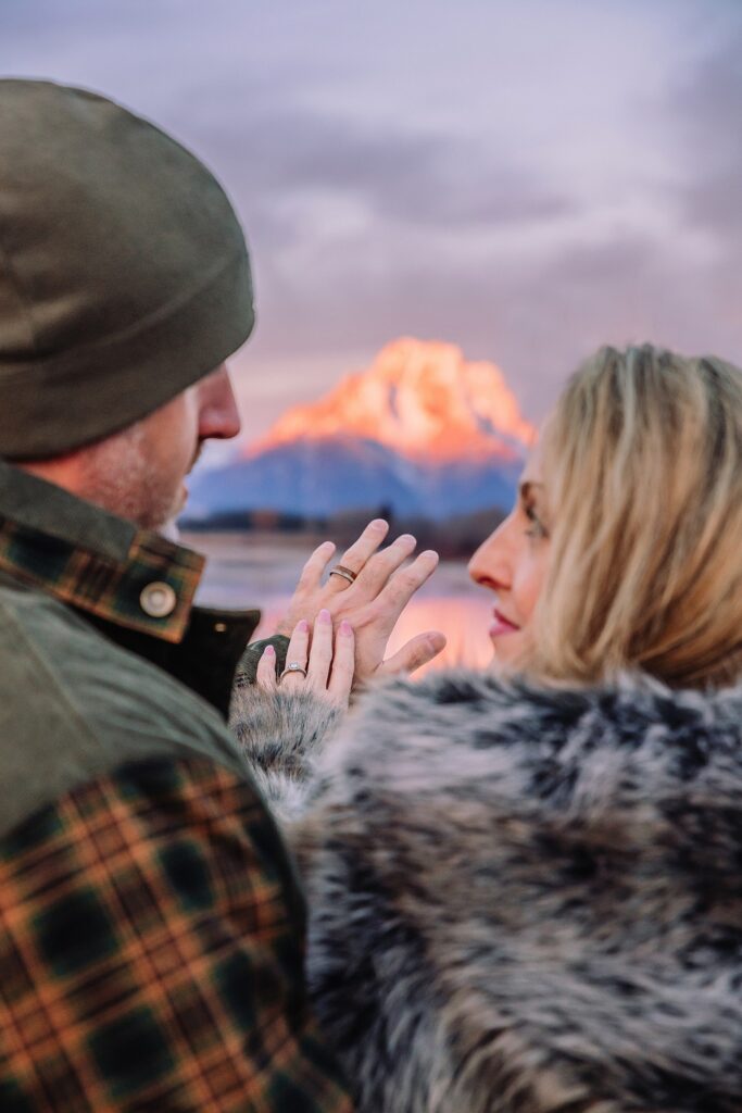 jackson hole anniversary photos at oxbow bend sunrise couple photography with fur coat jackson hole wyoming romantic river shoreline couples portraits grand teton national park october sunrise photography session oxbow bend