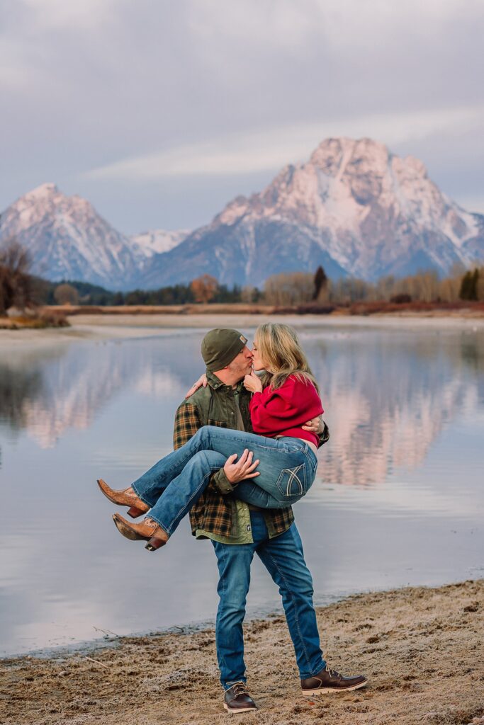 jackson hole anniversary photos at oxbow bend sunrise couple photography with fur coat jackson hole wyoming romantic river shoreline couples portraits grand teton national park october sunrise photography session oxbow bend