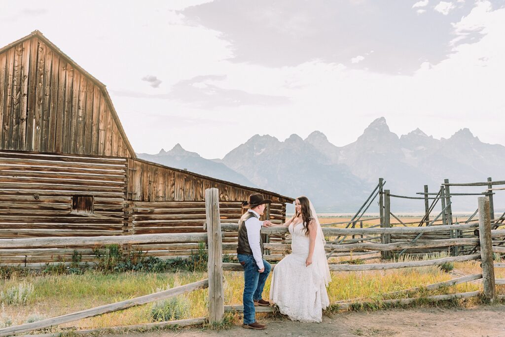 Jackson Hole wedding photographer barn photos Mormon Row western glam wedding dress deep neckline lace details mountain elopement with Teton backdrop intimate Jackson Hole wedding photography
