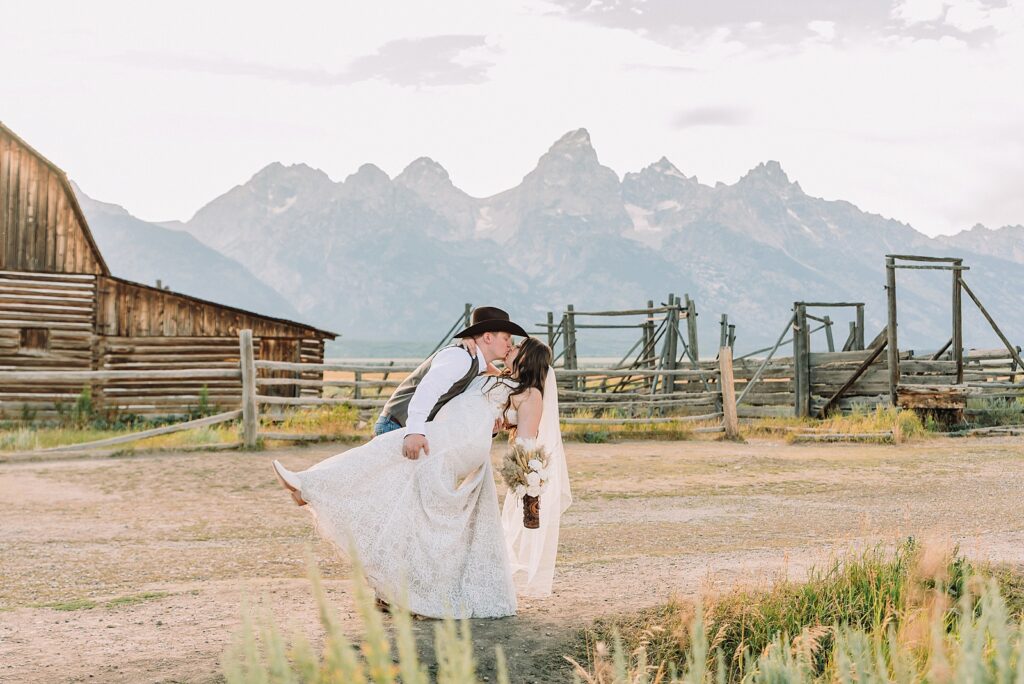 Jackson Hole wedding photographer barn photos Mormon Row western glam wedding dress deep neckline lace details mountain elopement with Teton backdrop intimate Jackson Hole wedding photography