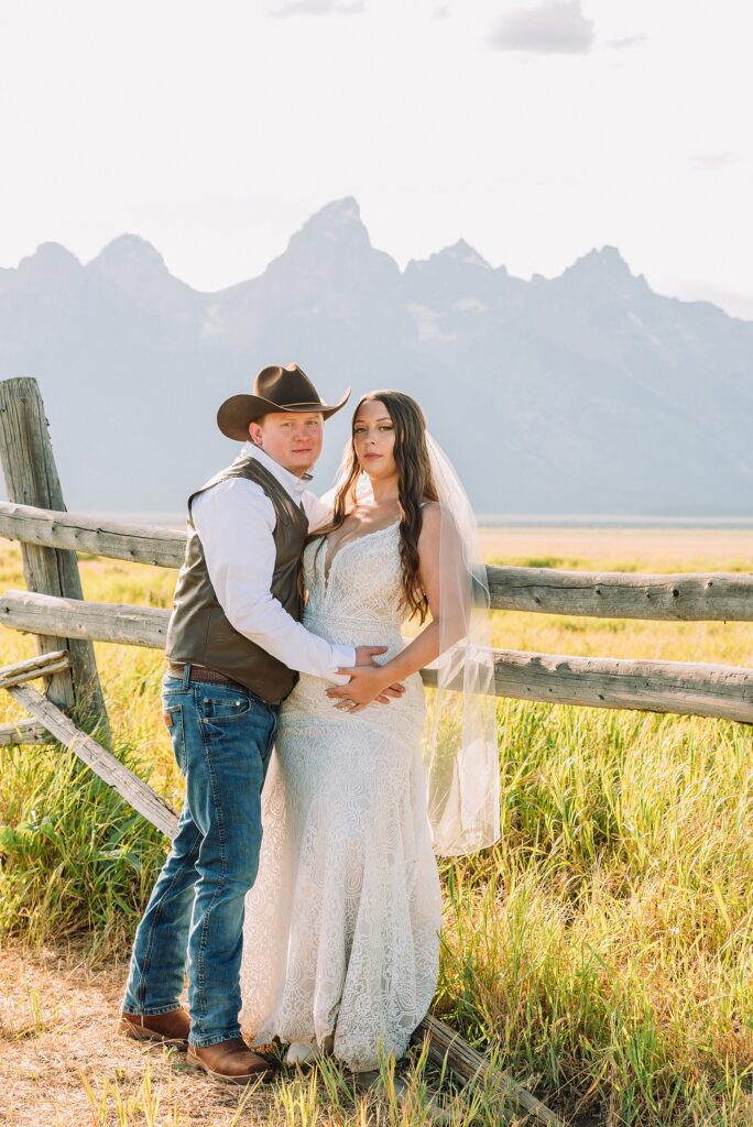Jackson Hole wedding photographer barn photos Mormon Row western glam wedding dress deep neckline lace details mountain elopement with Teton backdrop intimate Jackson Hole wedding photography