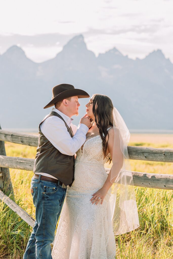 Jackson Hole wedding photographer barn photos Mormon Row western glam wedding dress deep neckline lace details mountain elopement with Teton backdrop intimate Jackson Hole wedding photography
