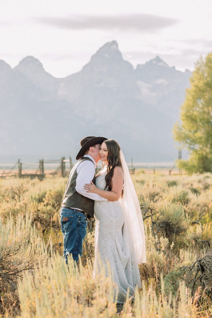 Jackson Hole wedding photographer barn photos Mormon Row western glam wedding dress deep neckline lace details mountain elopement with Teton backdrop intimate Jackson Hole wedding photography