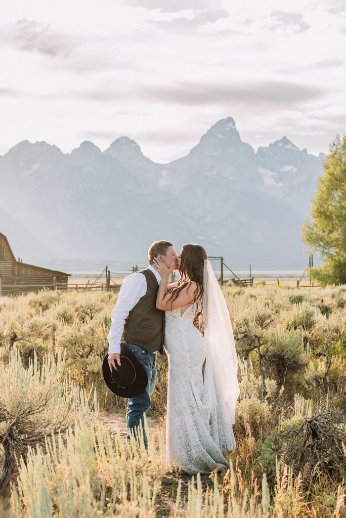 Jackson Hole wedding photographer barn photos Mormon Row western glam wedding dress deep neckline lace details mountain elopement with Teton backdrop intimate Jackson Hole wedding photography