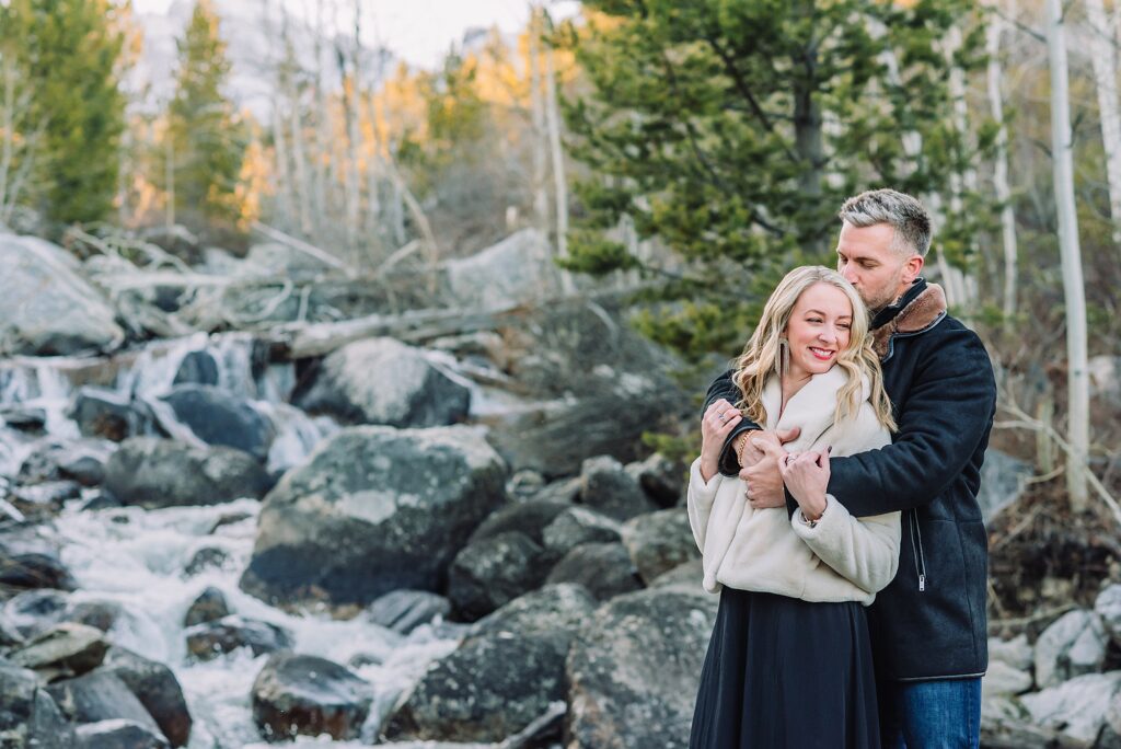 Luxury western couples photography Jackson Hole Early season mountain engagement photos Tetons Taggart Lake trailhead anniversary photography session Cascade bridge couples portraits Grand Teton National Park Faux fur coat mountain couples photoshoot Wyoming