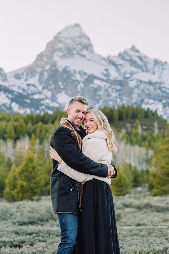 Luxury western couples photography Jackson Hole Early season mountain engagement photos Tetons Taggart Lake trailhead anniversary photography session Cascade bridge couples portraits Grand Teton National Park Faux fur coat mountain couples photoshoot Wyoming