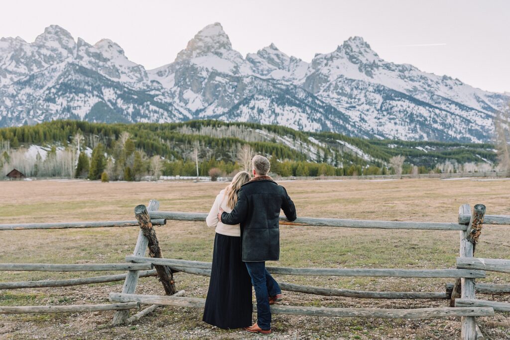 Grand Teton couples anniversary photos spring session Wyoming mountain bridge waterfall couple portraits Luxury western couples photography Jackson Hole Early season mountain engagement photos Tetons