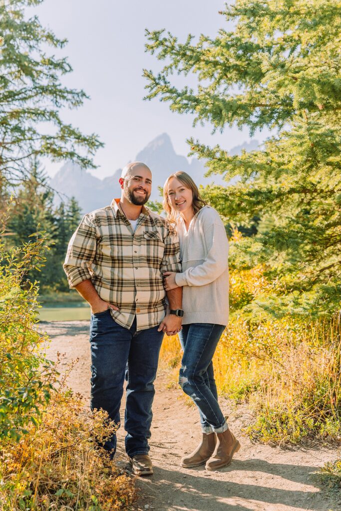 Jackson Hole Photographer Casual mountain engagement photos with jeans Fall engagement session Grand Tetons Wyoming Cream sweater engagement photos mountain backdrop