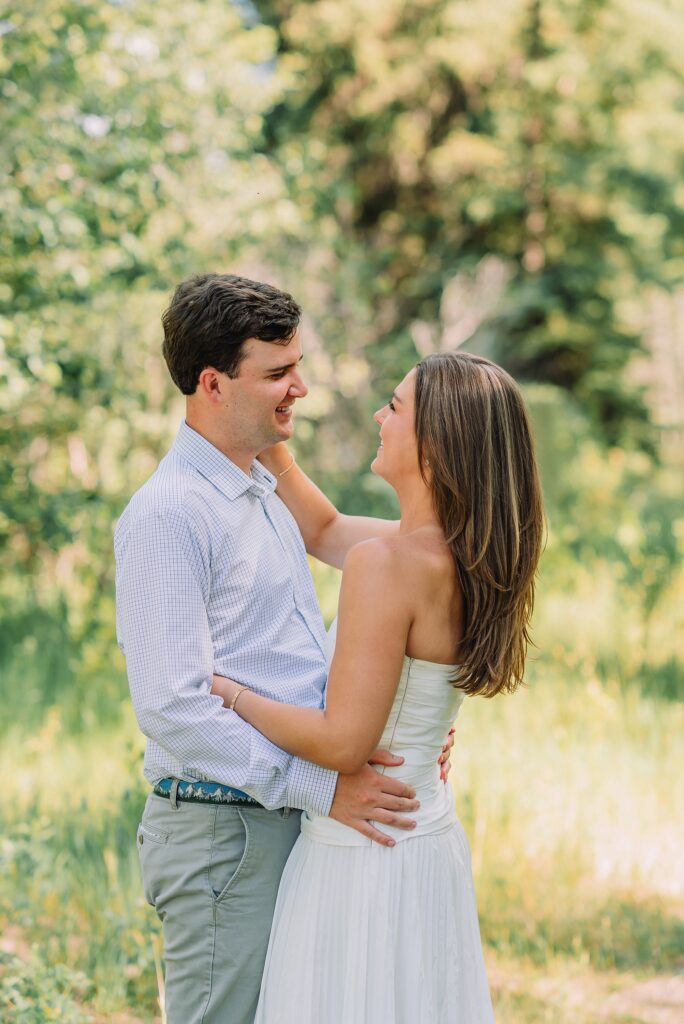 mountain engagement session with river views Grand Tetons white dress engagement photos in nature shaded forest engagement photos summer session romantic nature engagement session July Wyoming