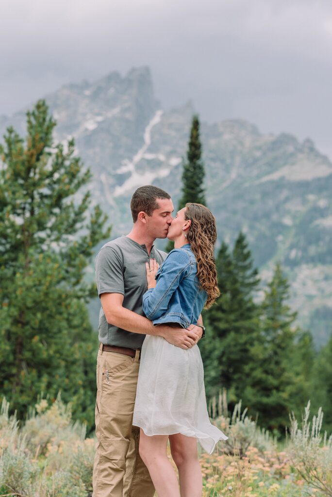 outdoor family photographer Teton mountains Wyoming Jenny Lake engagement photos windy conditions Mountain View Turnout couple portraits Grand Tetons Teton Glacier Turnout western family photos Grand Teton vacation photographer coordinating family outfits without matching
