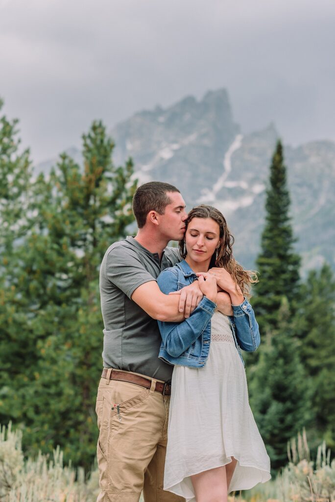 outdoor family photographer Teton mountains Wyoming Jenny Lake engagement photos windy conditions Mountain View Turnout couple portraits Grand Tetons Teton Glacier Turnout western family photos Grand Teton vacation photographer coordinating family outfits without matching