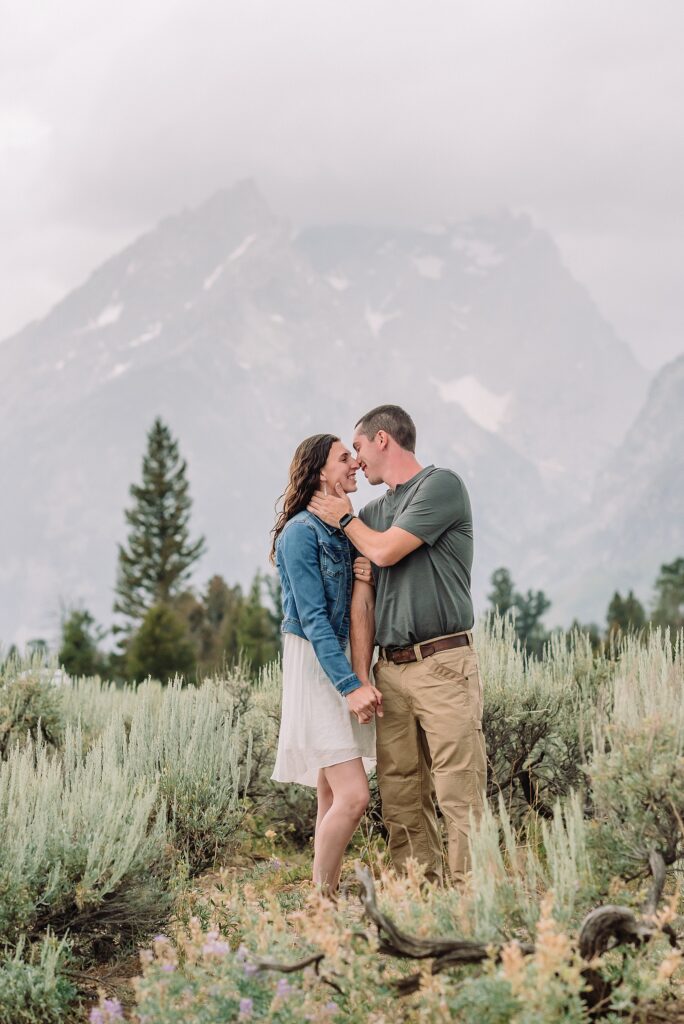 outdoor family photographer Teton mountains Wyoming Jenny Lake engagement photos windy conditions Mountain View Turnout couple portraits Grand Tetons Teton Glacier Turnout western family photos Grand Teton vacation photographer coordinating family outfits without matching