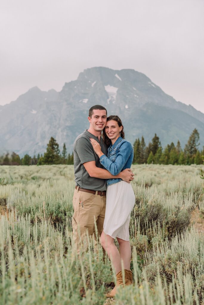 outdoor family photographer Teton mountains Wyoming Jenny Lake engagement photos windy conditions Mountain View Turnout couple portraits Grand Tetons Teton Glacier Turnout western family photos Grand Teton vacation photographer coordinating family outfits without matching