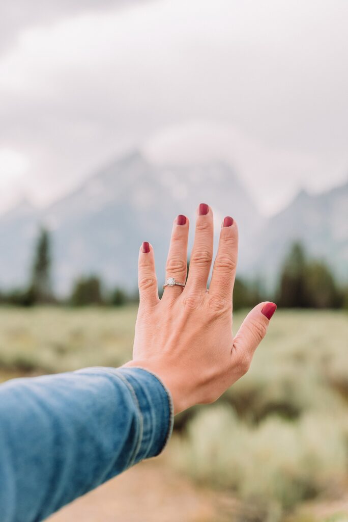 outdoor family photographer Teton mountains Wyoming Jenny Lake engagement photos windy conditions Mountain View Turnout couple portraits Grand Tetons Teton Glacier Turnout western family photos Grand Teton vacation photographer coordinating family outfits without matching