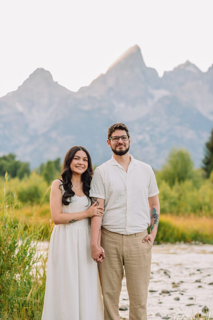 Schwabacher Landing engagement photos Grand Teton National Park white corset dress mountain engagement session Wyoming sunset engagement photos Teton mountain range backdrop couple wearing white outfits Grand Teton engagement shoot Jackson Hole Engagement Photographer