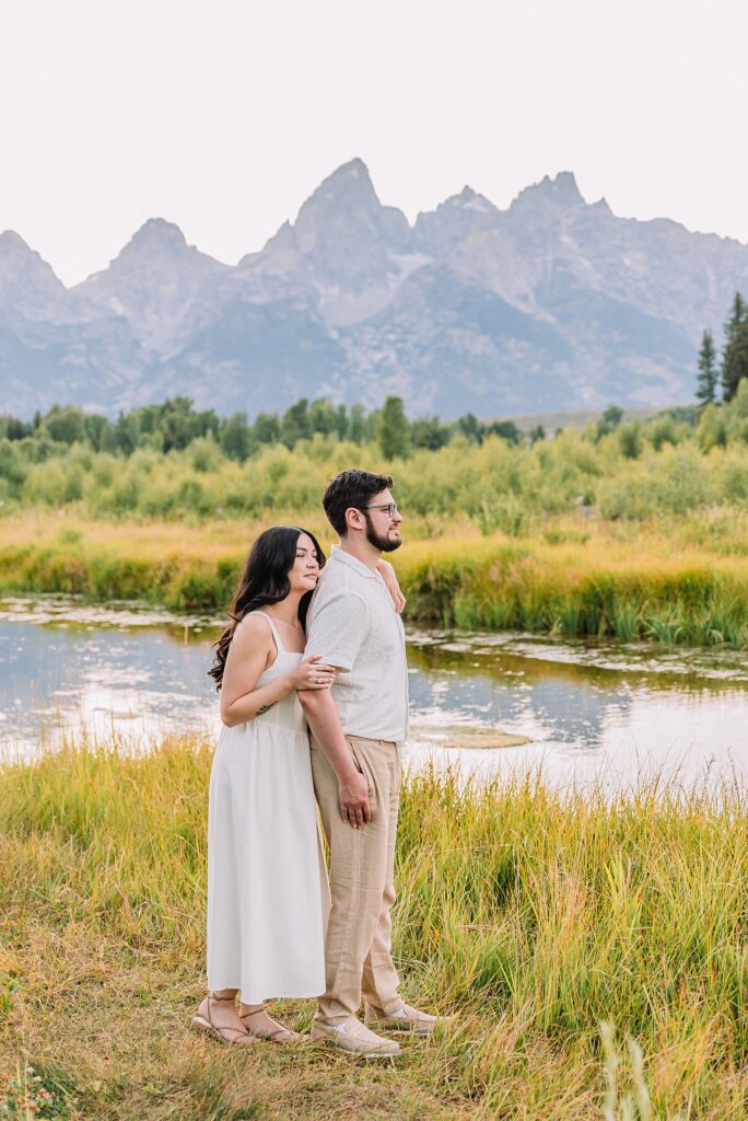 Schwabacher Landing engagement photos Grand Teton National Park white corset dress mountain engagement session Wyoming sunset engagement photos Teton mountain range backdrop couple wearing white outfits Grand Teton engagement shoot Jackson Hole Engagement Photographer