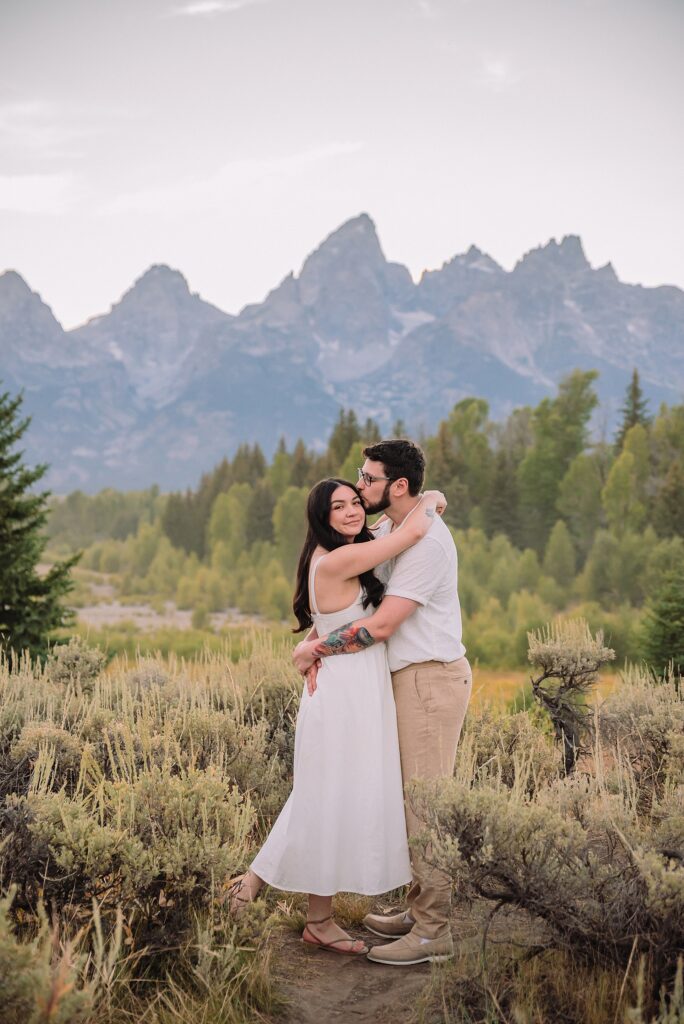 Schwabacher Landing engagement photos Grand Teton National Park white corset dress mountain engagement session Wyoming sunset engagement photos Teton mountain range backdrop couple wearing white outfits Grand Teton engagement shoot Jackson Hole Engagement Photographer