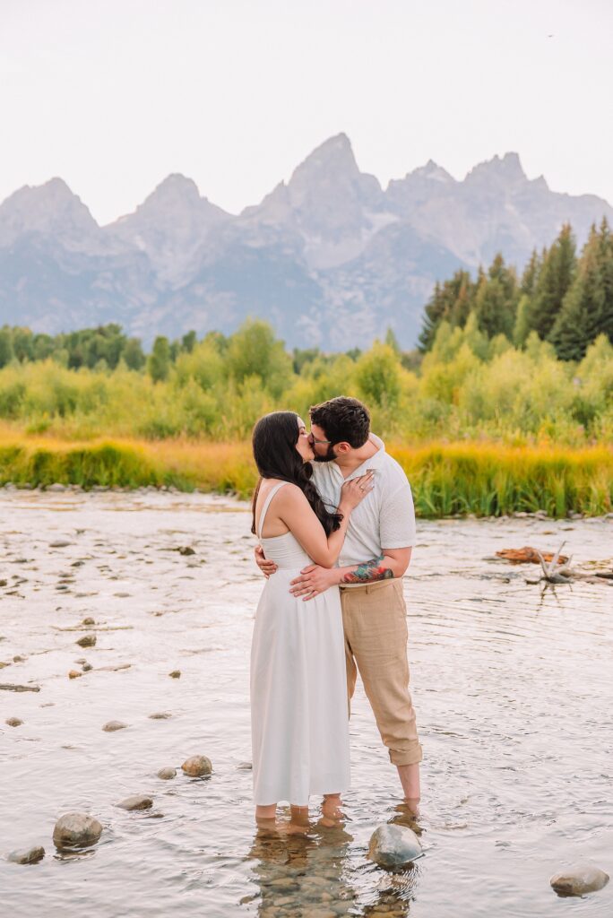 Schwabacher Landing engagement photos Grand Teton National Park white corset dress mountain engagement session Wyoming sunset engagement photos Teton mountain range backdrop couple wearing white outfits Grand Teton engagement shoot Jackson Hole Engagement Photographer