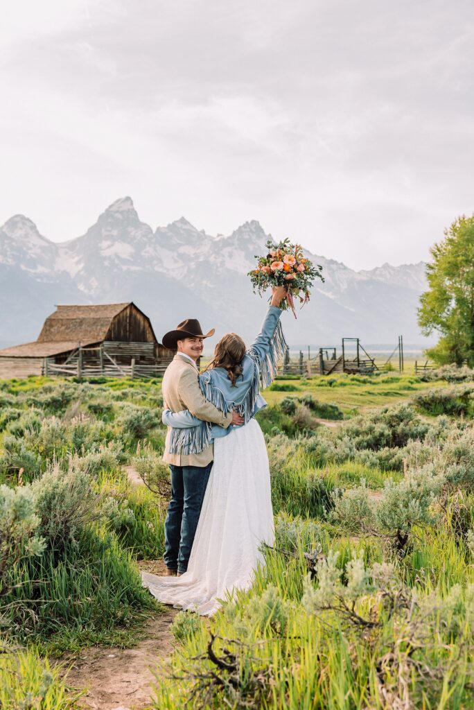 Jackson Hole Wyoming wedding photography Jackson Hole wedding photography Mormon Row portraits Bride fringed jean jacket Western wedding style Mormon Row Rustic Barn Wedding