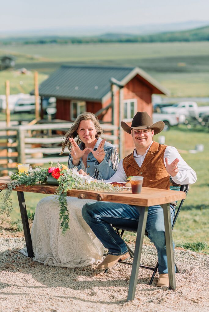 Rustic Wyoming outdoor wedding reception dance floor Faith-based knot tying wedding ceremony Wyoming Candid hilarious cake cutting wedding photos Two-day Wyoming wedding ceremony and reception photography destination Wyoming wedding photography
