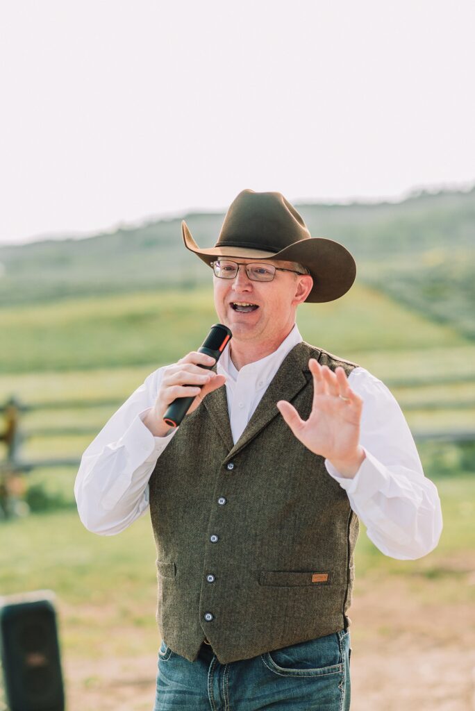 Rustic Wyoming outdoor wedding reception dance floor Faith-based knot tying wedding ceremony Wyoming Candid hilarious cake cutting wedding photos Two-day Wyoming wedding ceremony and reception photography destination Wyoming wedding photography