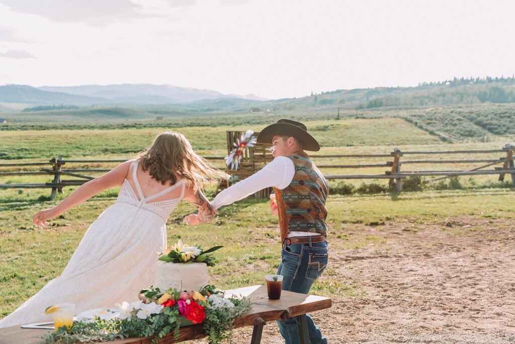 Rustic Wyoming outdoor wedding reception dance floor Faith-based knot tying wedding ceremony Wyoming Candid hilarious cake cutting wedding photos Two-day Wyoming wedding ceremony and reception photography destination Wyoming wedding photography