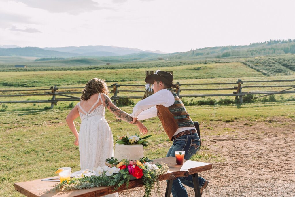 Rustic Wyoming outdoor wedding reception dance floor Faith-based knot tying wedding ceremony Wyoming Candid hilarious cake cutting wedding photos Two-day Wyoming wedding ceremony and reception photography destination Wyoming wedding photography