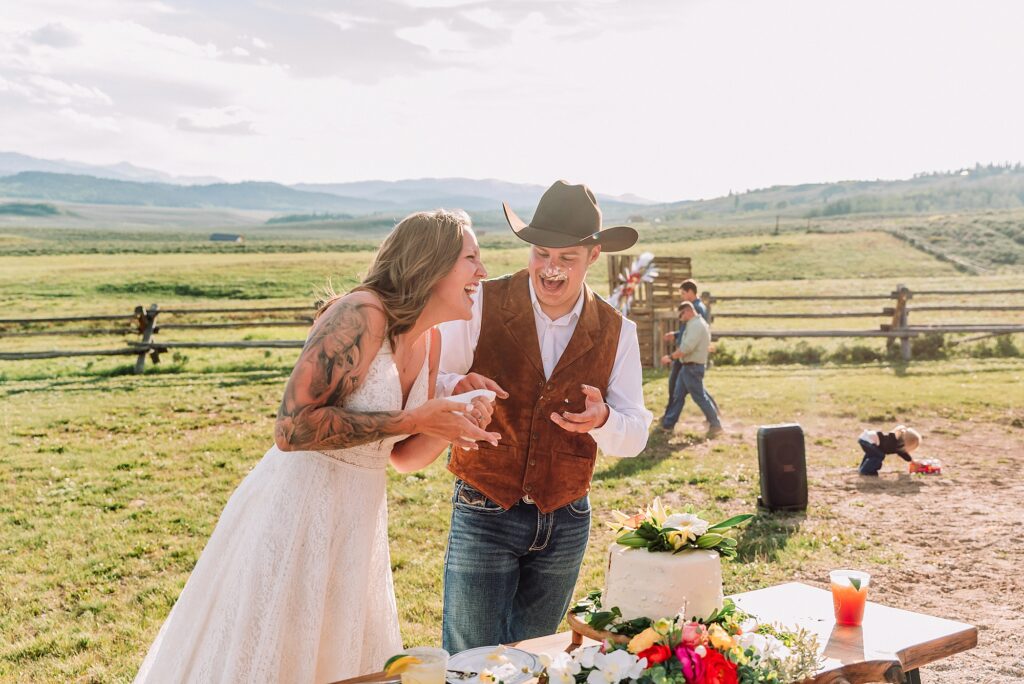 Rustic Wyoming outdoor wedding reception dance floor Faith-based knot tying wedding ceremony Wyoming Candid hilarious cake cutting wedding photos Two-day Wyoming wedding ceremony and reception photography destination Wyoming wedding photography