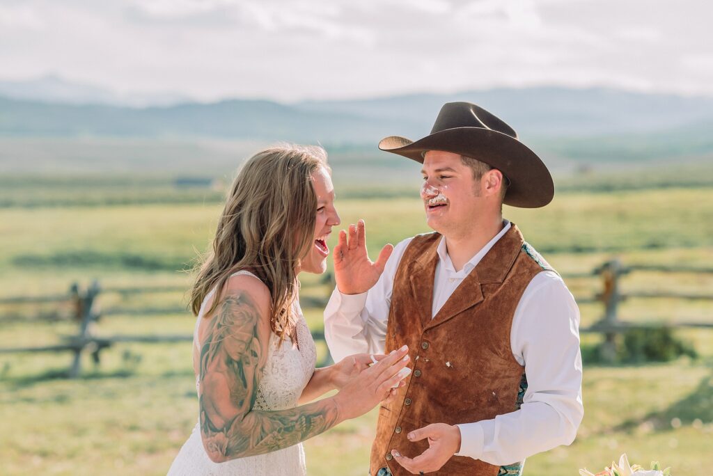 Rustic Wyoming outdoor wedding reception dance floor Faith-based knot tying wedding ceremony Wyoming Candid hilarious cake cutting wedding photos Two-day Wyoming wedding ceremony and reception photography destination Wyoming wedding photography