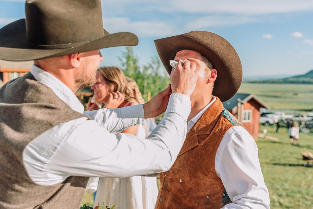 Rustic Wyoming outdoor wedding reception dance floor Faith-based knot tying wedding ceremony Wyoming Candid hilarious cake cutting wedding photos Two-day Wyoming wedding ceremony and reception photography destination Wyoming wedding photography